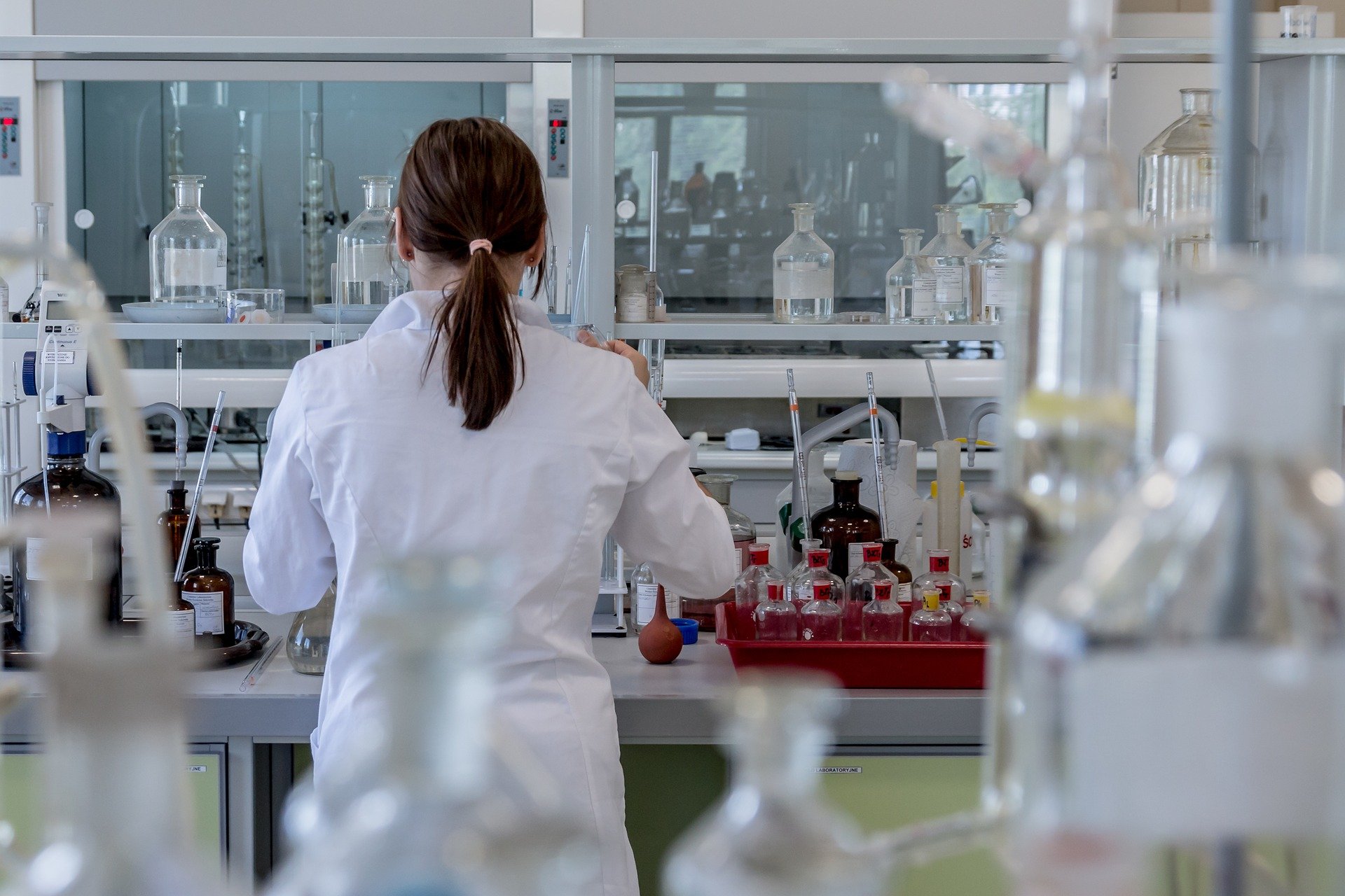 person in lab coat doing experiments in a lab setting